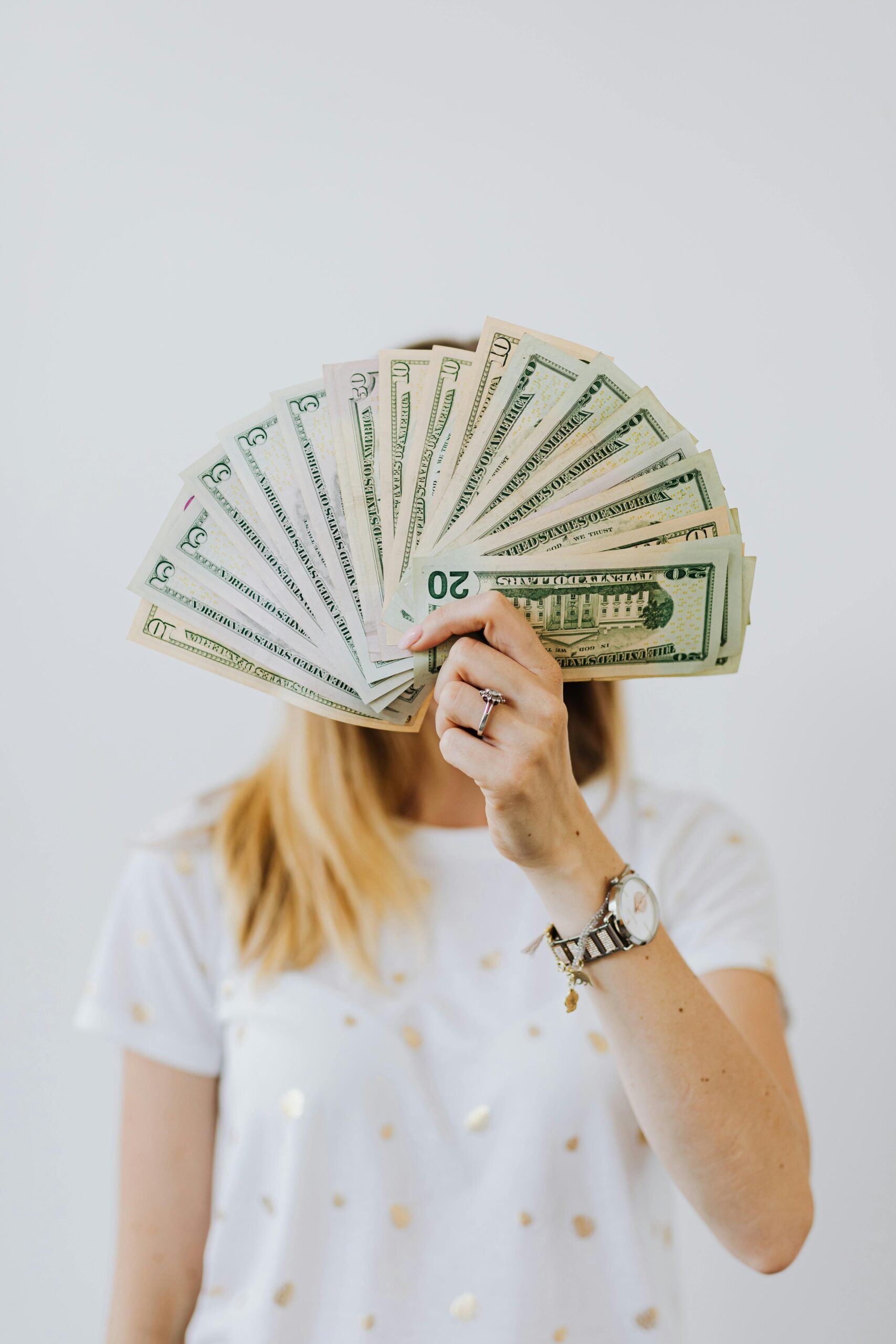 Woman Holding Fan of Us Dollar Bills